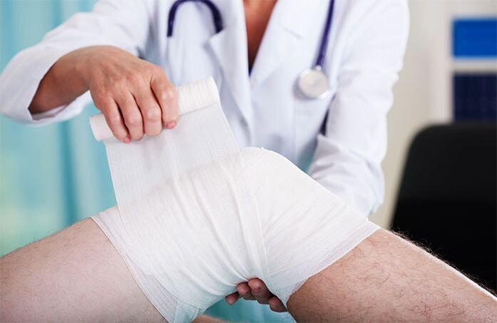 lekarz bandażujący staw kolanowy z artrozą